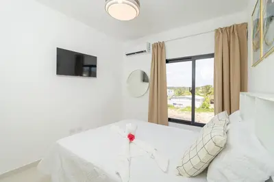 a bedroom with a white bed and a window at Cozy 2BR Apartment in Sunshine Bayahibe in San Rafael del Yuma