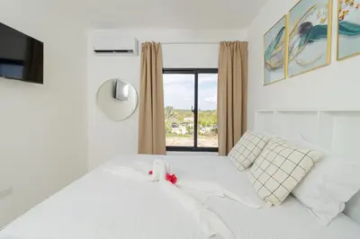a bedroom with a white bed with a window at Cozy 2BR Apartment in Sunshine Bayahibe in San Rafael del Yuma