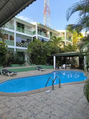 a swimming pool in front of a building at Escape en terrazas del caribe con psicina y playa in Boca Chica