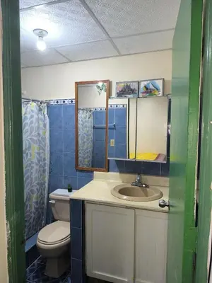 a bathroom with a toilet and a sink at Escape en terrazas del caribe con psicina y playa in Boca Chica