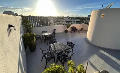 a patio with tables and chairs on a balcony at Casa Estrellita-Romantic getaway in Santo Domingo
