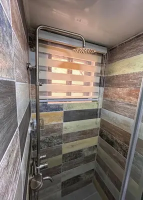 a bathroom with a shower with wooden tiles at Casa Estrellita-Romantic getaway in Santo Domingo