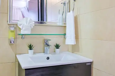 a bathroom with a white sink and a mirror at Cozy City Center 2BD Condo, in Santo Domingo