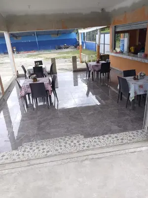 a dining area with tables and chairs and a patio at Hotel Doña kila in El Catey