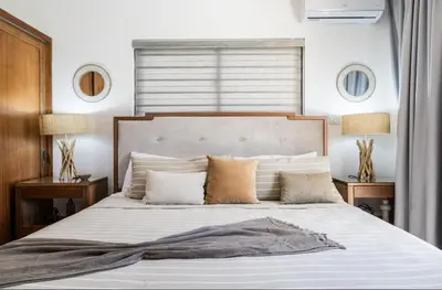 a bedroom with a large white bed with pillows at My luxury villa in Sosúa