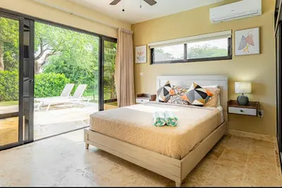 a bedroom with a bed and a large window at My luxury villa in Sosúa
