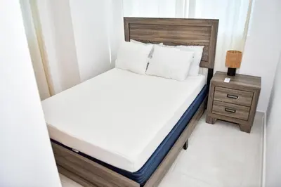 a small bedroom with a bed and a night stand at Paraíso encantado Juan Dolio, Confort y Seguridad in Villas del Mar