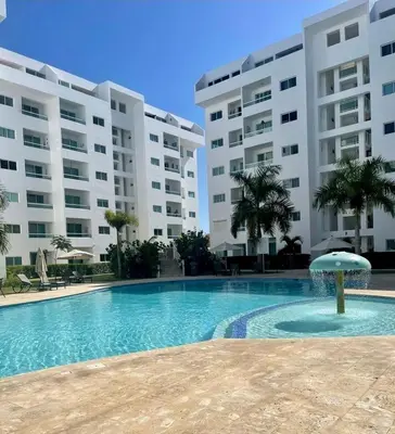 a swimming pool in front of two large buildings at Paraíso encantado Juan Dolio, Confort y Seguridad in Villas del Mar