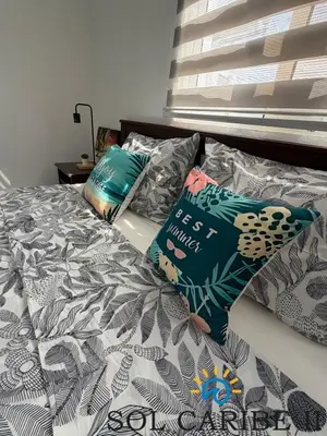 a bed with pillows on it in a bedroom at Bright & Airy Apartment in Bayahibe