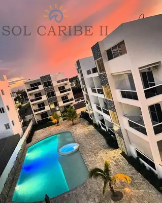 a swimming pool in front of some apartment buildings at Bright & Airy Apartment in Bayahibe