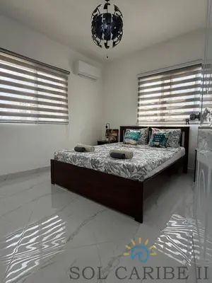 a bedroom with a bed in a room with windows at Bright & Airy Apartment in Bayahibe