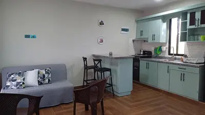a living room with a couch and a kitchen at Villa Sol de Campo in Las Galeras