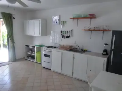 a kitchen with white cabinets and a stove top oven at Surf & Stay Waveriders, Encuentro in Cabarete