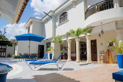 a villa with a swimming pool and blue lounge chairs at Villa La Dueña - Vista Hermosa Luxury Retreat, 5BR Villa with Pool, Swim-Up Bar, Jacuzzi, Chef's Kitchen, Fast Wi-Fi, Full AC, EV Charger and Solar Power, Ideal for Families & Groups in Cancino