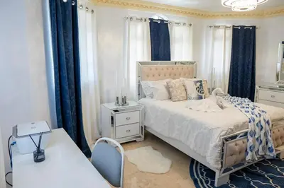 a bedroom with a bed and a table with a chair at Villa La Dueña - Vista Hermosa Luxury Retreat, 5BR Villa with Pool, Swim-Up Bar, Jacuzzi, Chef's Kitchen, Fast Wi-Fi, Full AC, EV Charger and Solar Power, Ideal for Families & Groups in Cancino