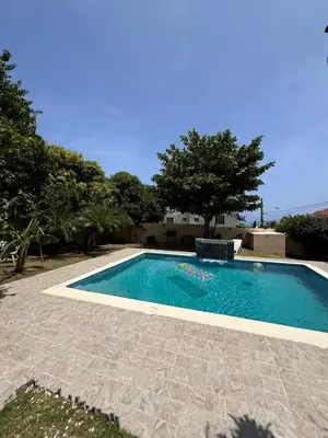 a swimming pool in a yard with a tree at Villa BayRum in San Felipe de Puerto Plata