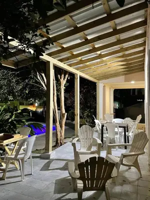 a group of white chairs and tables on a patio at Villa BayRum in San Felipe de Puerto Plata