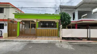 a green house with a gate on a street at Airbnbbuenhogar in Concepción de La Vega
