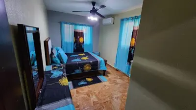 a bedroom with two beds and a ceiling fan at Airbnbbuenhogar in Concepción de La Vega