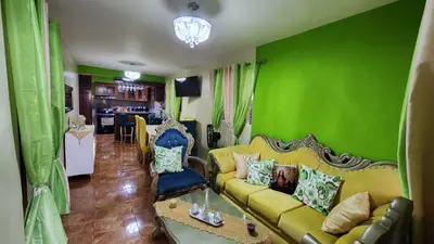 a living room with green walls and a yellow couch at Airbnbbuenhogar in Concepción de La Vega