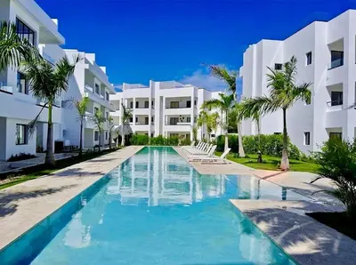 a swimming pool in front of a building at Casa Lulu in Punta Cana