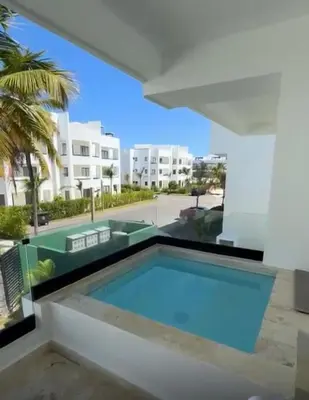 a swimming pool in front of a building at Casa Lulu in Punta Cana