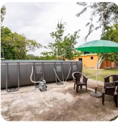a patio with an umbrella and a camera and chairs at paradise ranch san cristobal in San Cristóbal