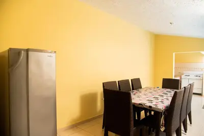 a dining room with a table and a refrigerator at Boom Ranch in Las Galeras