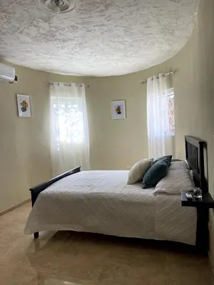 a bedroom with a bed with two pillows on it at Casa Kaibana - 8 Pax, con piscina, cerca del mar in Las Galeras