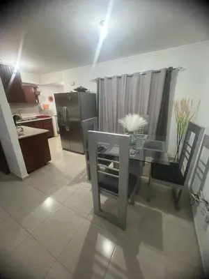 a kitchen with a glass table and a refrigerator at Tú hogar en ciudad Juan Bosch in Los Paredones