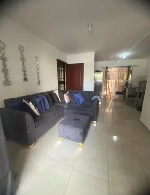 a living room with a couch and a table at Tú hogar en ciudad Juan Bosch in Los Paredones