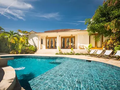 a swimming pool in front of a house at Tropical Roga Villa with Private Pool in Cabarete