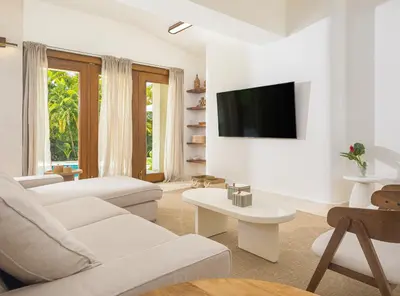 a white living room with a couch and a tv at Tropical Roga Villa with Private Pool in Cabarete