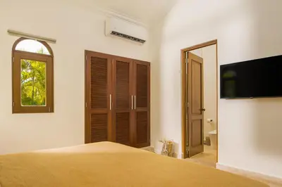 a bedroom with a bed and a flat screen tv at Tropical Roga Villa with Private Pool in Cabarete