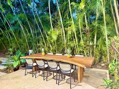 a wooden table with four chairs around it at Tropical Roga Villa with Private Pool in Cabarete