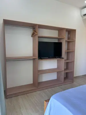 a entertainment center with a television and shelves at Refugio Verde Las Terrenas in Las Terrenas