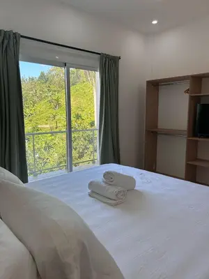 a bedroom with a bed with two towels on it at Refugio Verde Las Terrenas in Las Terrenas