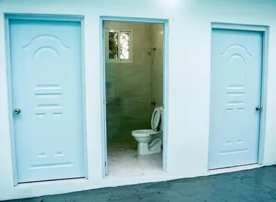 a bathroom with two blue doors and a toilet at Centrally located in El pino la vega, space for 8 or more guest, heated pool in El Pino