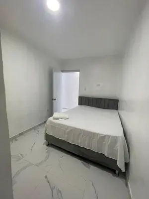 a white bedroom with a bed and a window at Apartamento 2 in Cancino