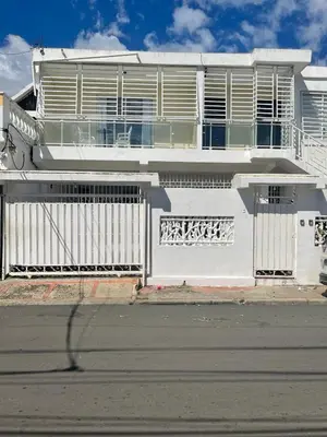 a white house with a white fence and a street at Apartamento 2 in Cancino