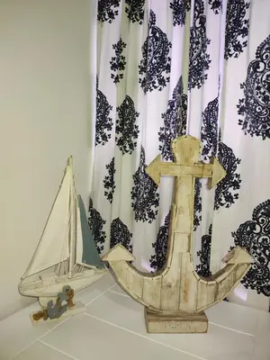 a wooden anchor and a toy boat in front of a curtain at Sunflower Bayahibe with pool in Bayahibe