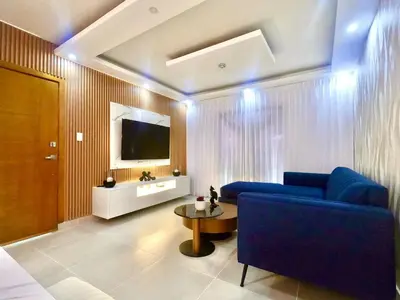a living room with a blue couch and a tv at The Chic Hideout full apt in san isidro Terrace in Juan López