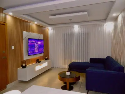 a living room with a blue couch and a tv at The Chic Hideout full apt in san isidro Terrace in Juan López