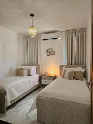 a bedroom with two beds and a chandelier at Paradise Escape Villa 201 2br Private Pool in Punta Cana