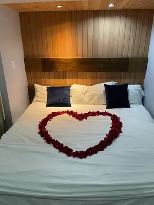 a heart made out of red flowers on a bed at La Mansion en SAJOMA Villa 15 3br with private Pool in San José de Las Matas
