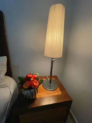 a table with a lamp and a vase of roses on it at La Mansion en SAJOMA Villa 15 3br with private Pool in San José de Las Matas
