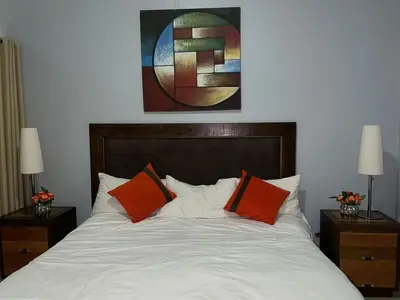 a bedroom with a bed with orange and white pillows at La Mansion en SAJOMA Villa 15 3br with private Pool in San José de Las Matas