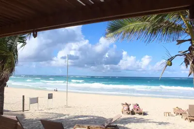a beach with two people sitting in chairs on the sand at Blue Paradise Punta Cana in Punta Cana