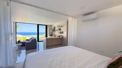 a bedroom with a bed and a view of the ocean at Tesoro Villas in Río San Juan