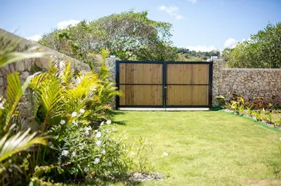 a garden with a wooden gate in a yard at Tesoro Villas in Río San Juan